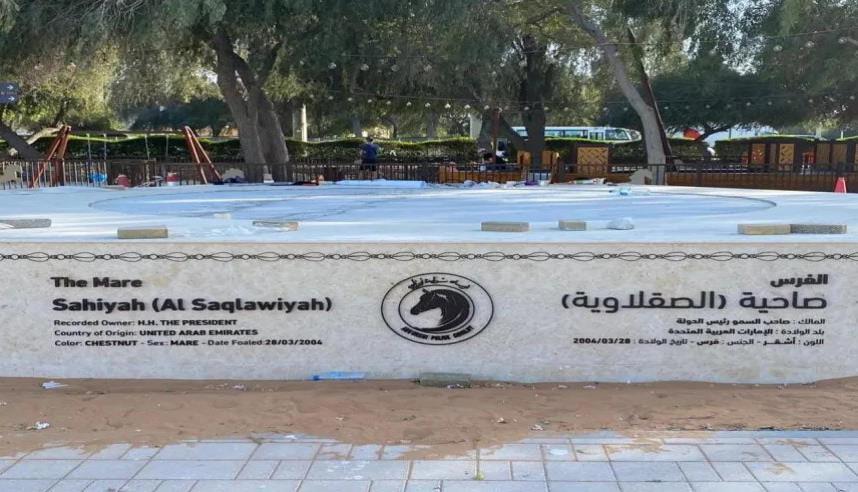 Wide-format etched plaque with bilingual lettering on a marble wall