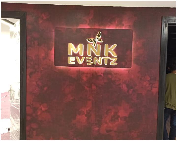 MNK Eventz — illuminated logo wall in deep red