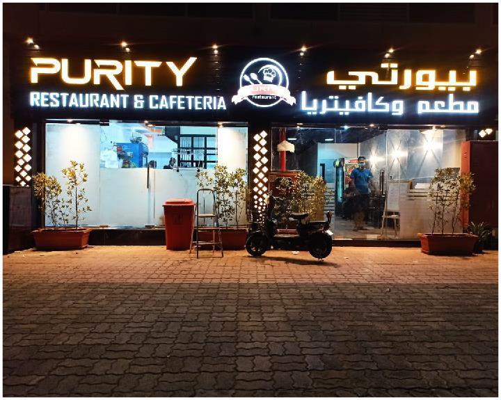 Purity Restaurant & Cafeteria — illuminated bilingual façade signage at night