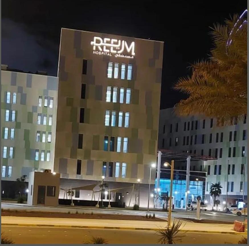 High-rise building at night with illuminated rooftop lettering